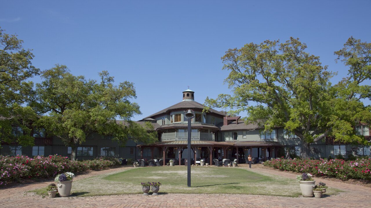 The Grand Hotel at Point Clear, Alabama, seen across a lawn courtyard with live oaks and flower beds