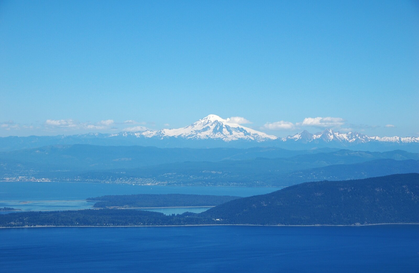 Orcas Island and the San Juan Islands in the foreground with the snow-covered cone of Mount Baker behind